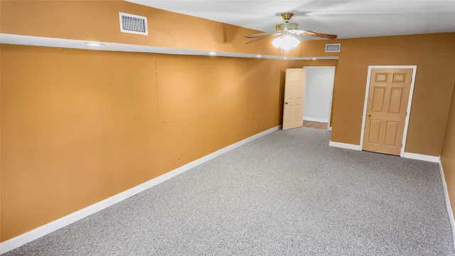 a view of empty room with ceiling fan