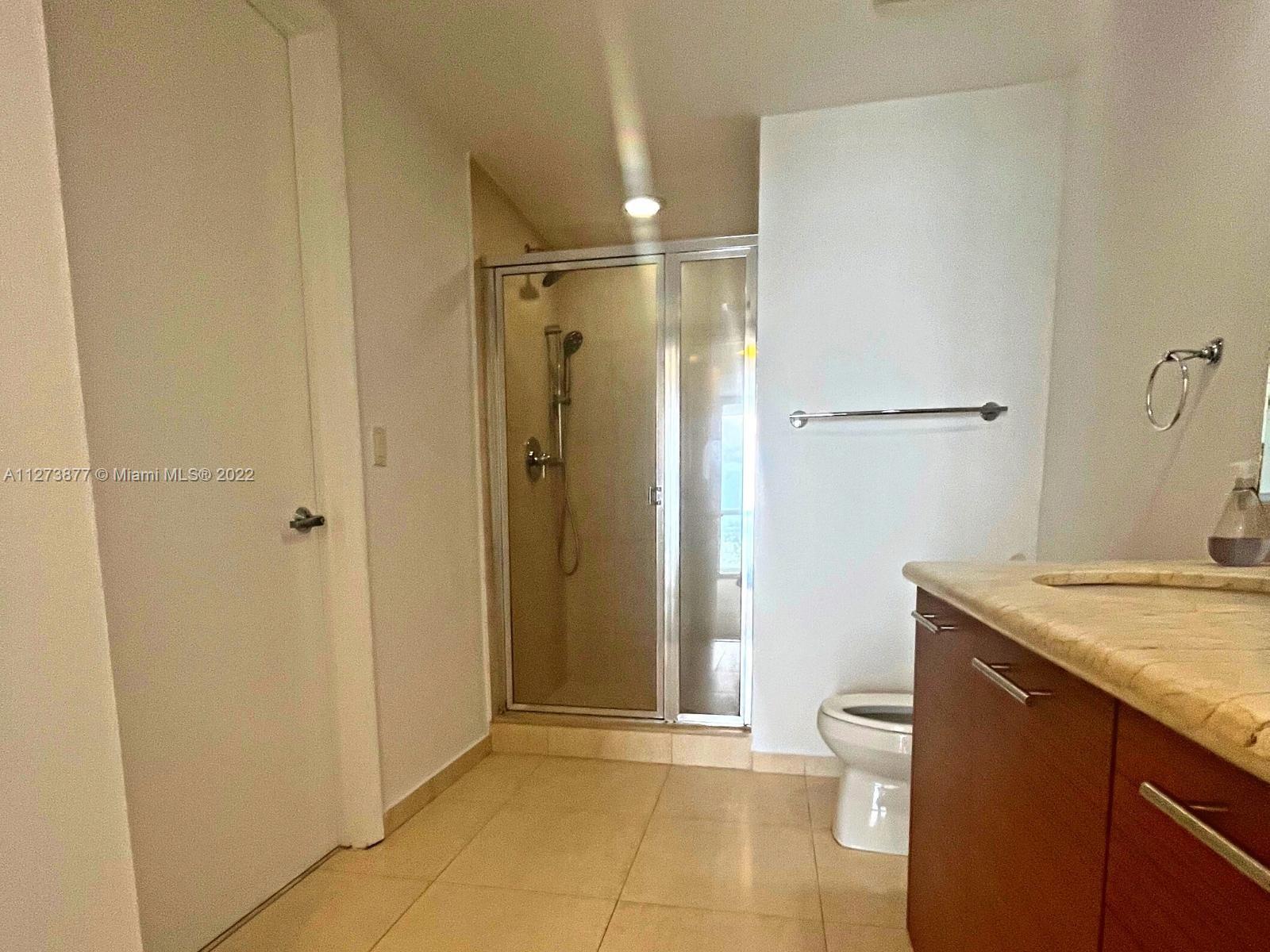 50 Biscayne Boulevard, Unit 5005 Miami, FL 33132 - Photo 11 of 20 a bathroom with a granite countertop sink and a mirror
