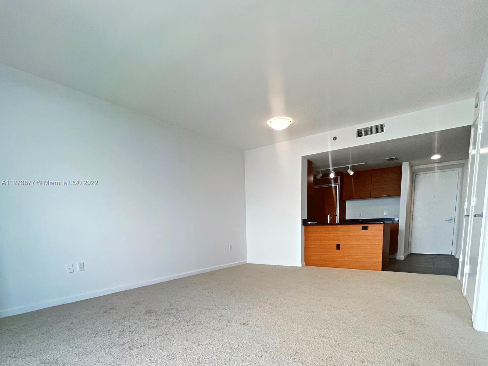 50 Biscayne Boulevard, Unit 5005 Miami, FL 33132 - Photo 4 of 20 a kitchen with a refrigerator and window