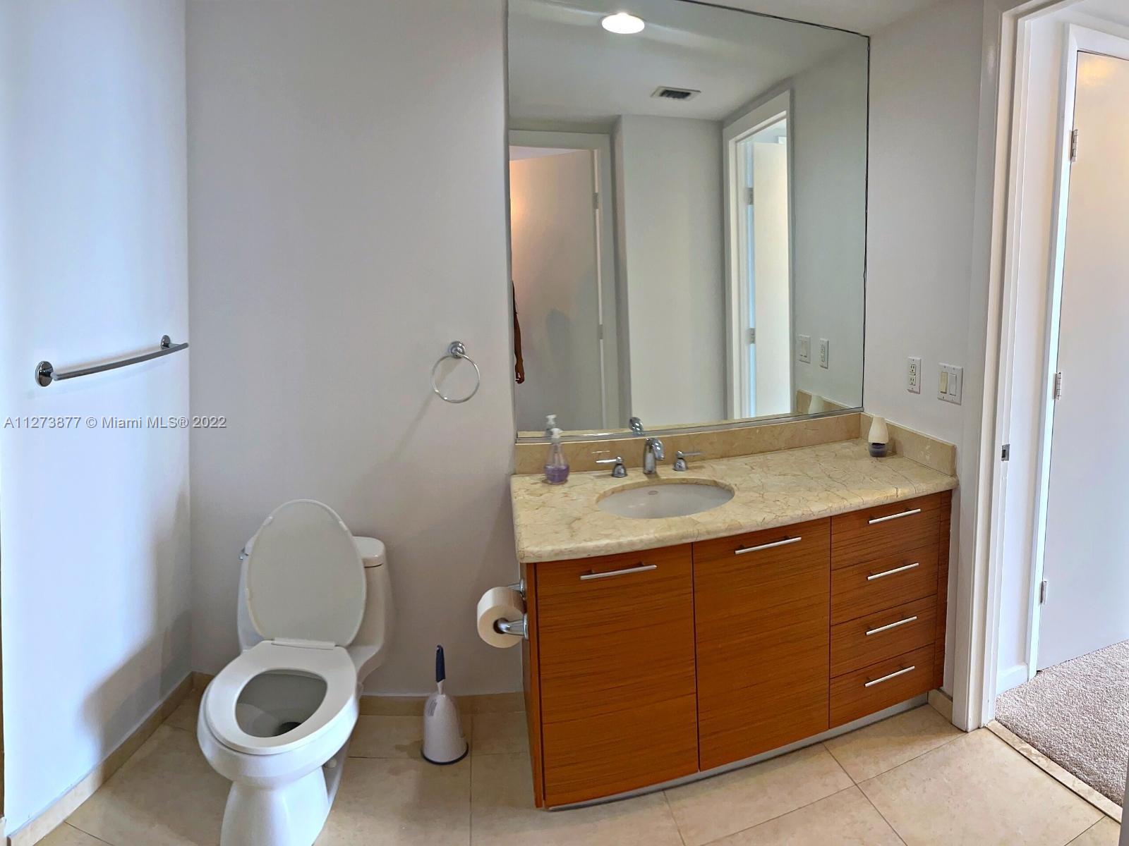 50 Biscayne Boulevard, Unit 5005 Miami, FL 33132 - Photo 10 of 20 a bathroom with a toilet sink and mirror