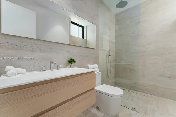 a bathroom with a sink a toilet and shower