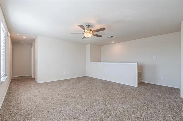 an empty room with closet and a ceiling fan