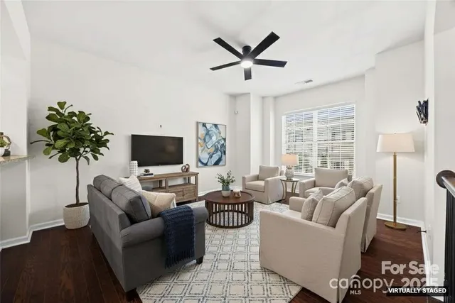 a living room with furniture a flat screen tv and a large window