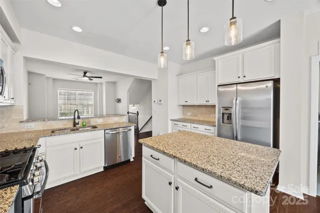 a kitchen with a sink a center island and a wooden floor