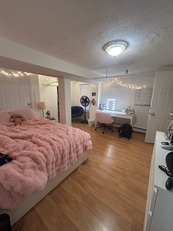 63 Hancock, Unit BR Boston, MA 02114 - Photo 5 of 12 a bedroom with a bed and wooden floor