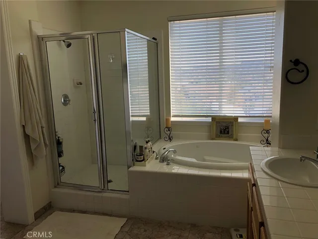 a bathroom with a granite countertop sink and a bathtub