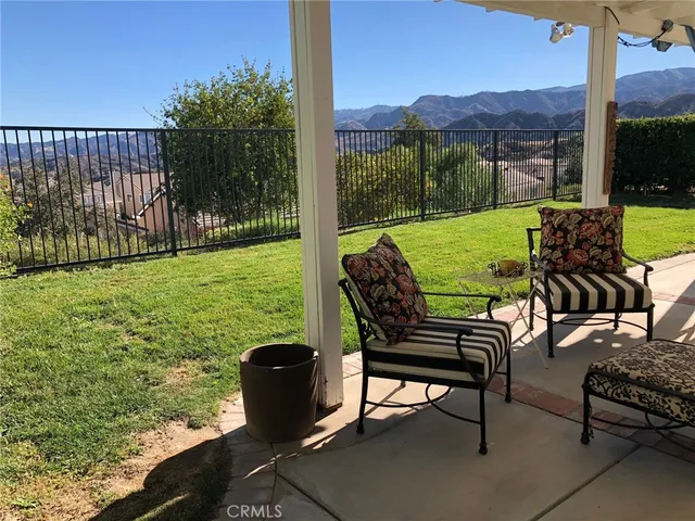 a view of a chairs and table in patio with a yard
