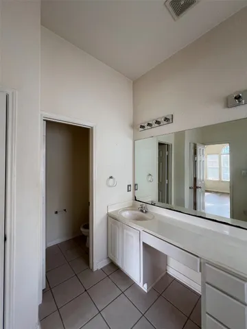 a bathroom with a double vanity sink mirror and toilet