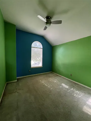 a view of a big room with windows and ceiling fan