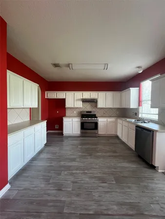 a large kitchen with a center island and stainless steel appliances