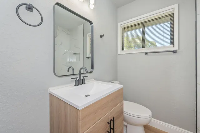a bathroom with a sink a toilet and a mirror