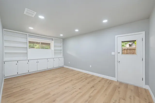 an empty room with wooden floor and window