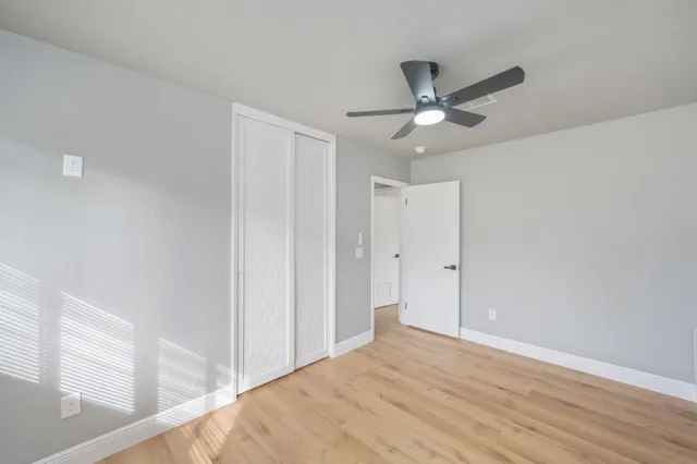 a view of a big room with wooden floor and a ceiling fan