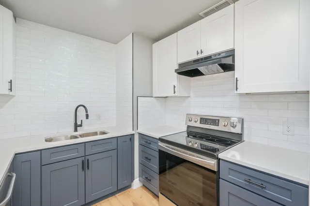 a kitchen with stainless steel appliances a sink stove and cabinets
