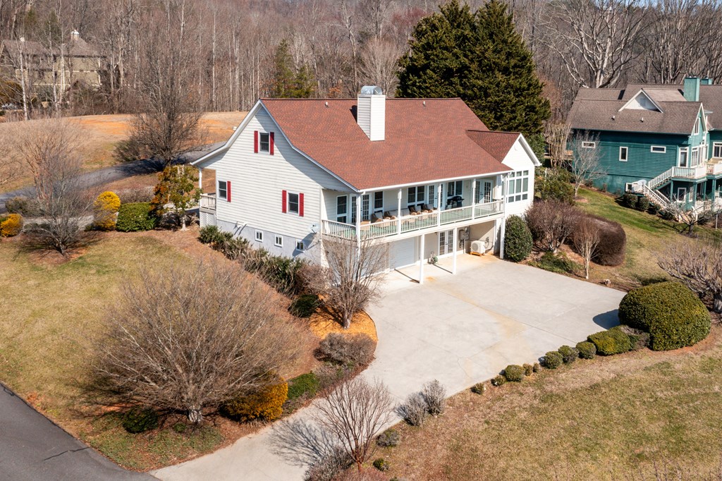 18 Foxfire Court Hayesville, NC 28904 - Photo 4 of 41 a view of a white house with a yard plants and large tree