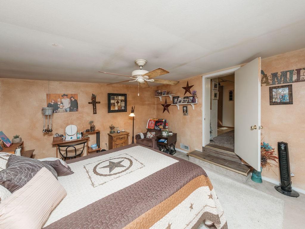 196 Perch Road Bowie, TX 76230 - Photo 15 of 30 a bedroom with furniture and a chandelier