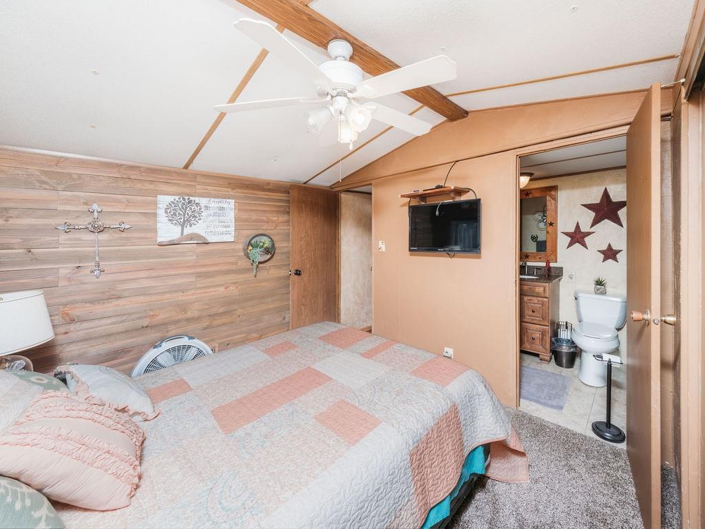 196 Perch Road Bowie, TX 76230 - Photo 22 of 30 a bedroom with a bed and a flat screen tv