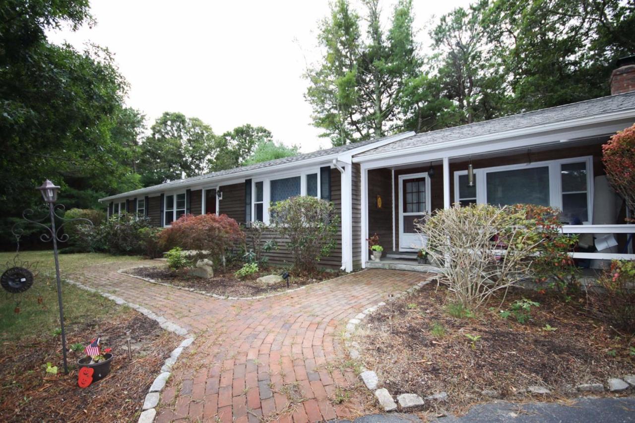140 Captain Samadrus Road Cotuit, MA 02635 - Photo 1 of 18 a view of a house with backyard and garden