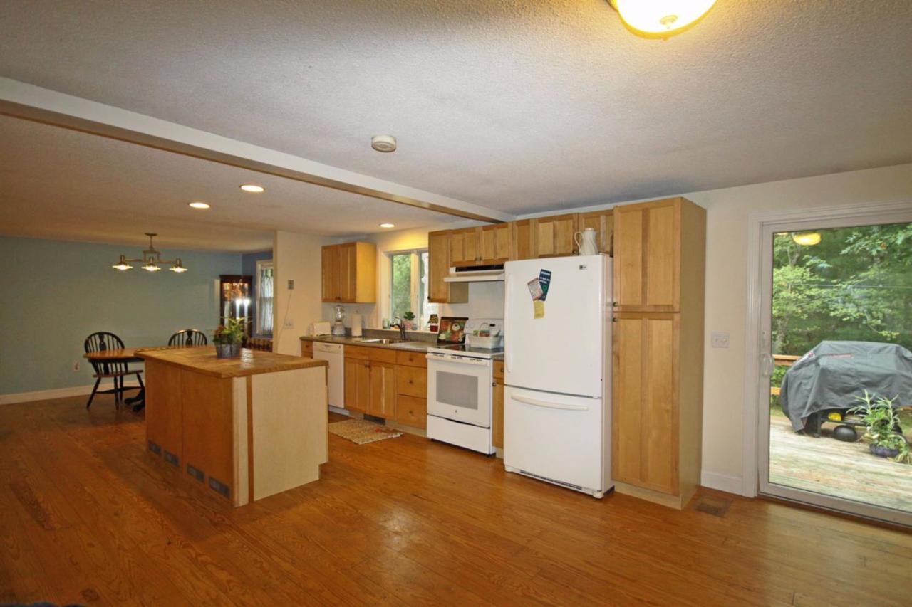 140 Captain Samadrus Road Cotuit, MA 02635 - Photo 2 of 18 a kitchen with cabinets and wooden floor