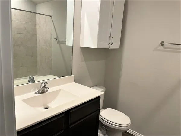 a bathroom with a sink a toilet and shower