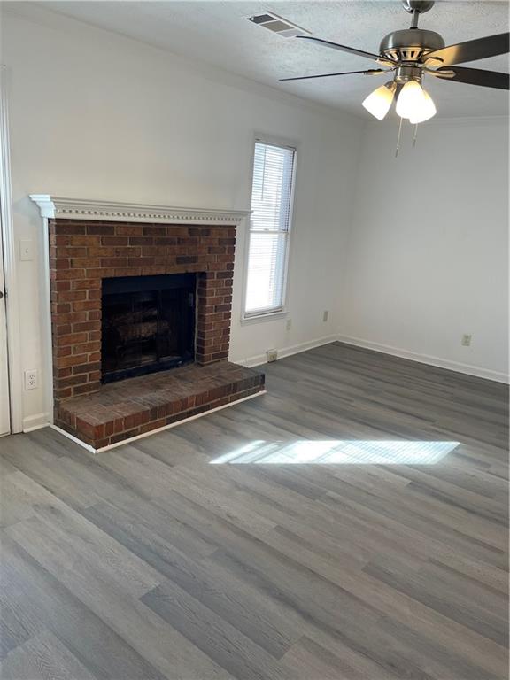 167 Walter Way Stone Mountain, GA 30083 - Photo 5 of 21 an empty room with wooden floor fireplace cabinet and a fireplace