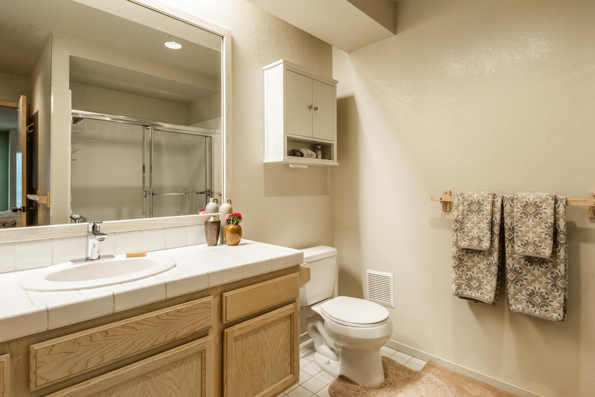 609 Golden Creek Road, Unit 609 Mammoth Lakes, CA 93546 - Photo 11 of 42 Bathroom featuring a wood-finish vanity with a tile countertop, integrated sink, and a large mirror