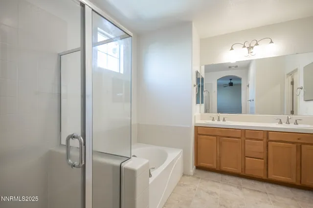 a large bathroom with a double vanity sink a mirror and a bathtub