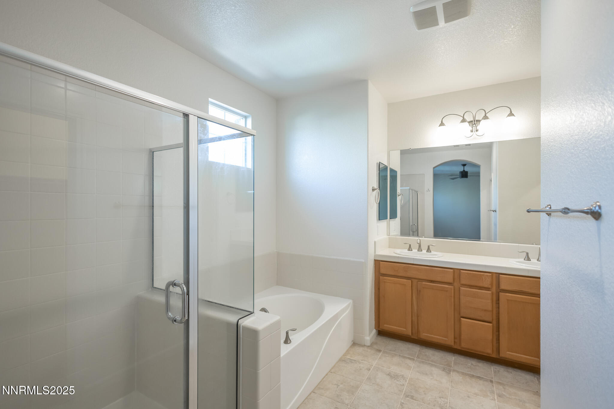 1715 Dark Horse Road, Unit B Reno, NV 89521 - Photo 24 of 39 a bathroom with a double vanity sink a large mirror and a bathtub