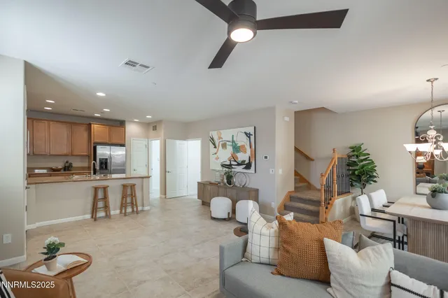a living room with furniture kitchen view and a wooden floor