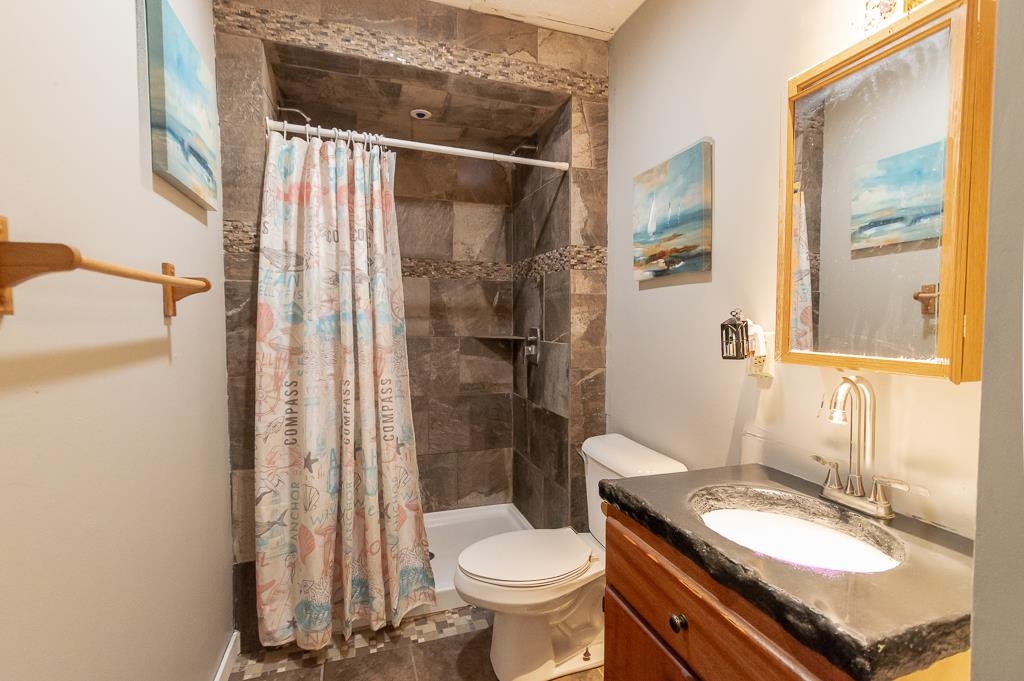 1045 North 2nd Street Rochelle, IL 61068 - Photo 6 of 15 a bathroom with a granite countertop toilet a sink and a mirror
