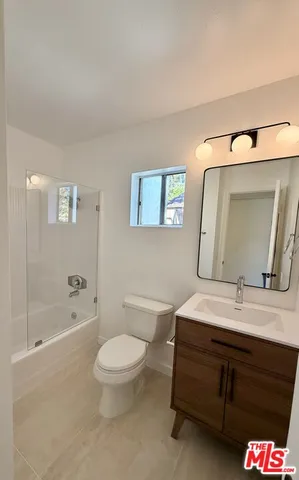 a bathroom with a double vanity sink toilet mirror and bathtub