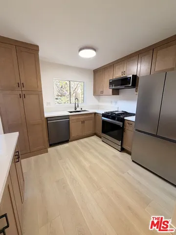 a large kitchen with a stove a sink dishwasher and a refrigerator