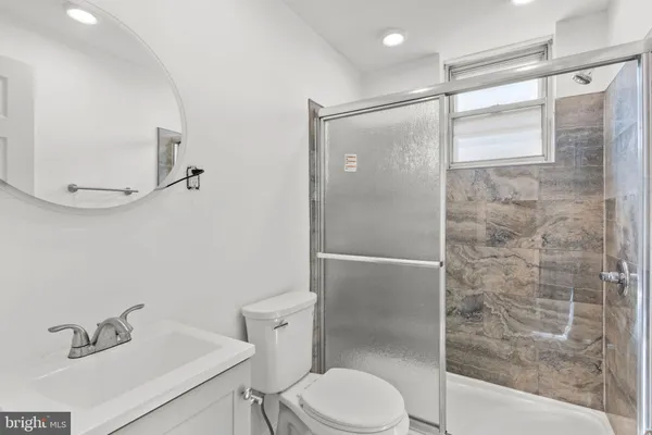 a bathroom with a shower a toilet and a sink