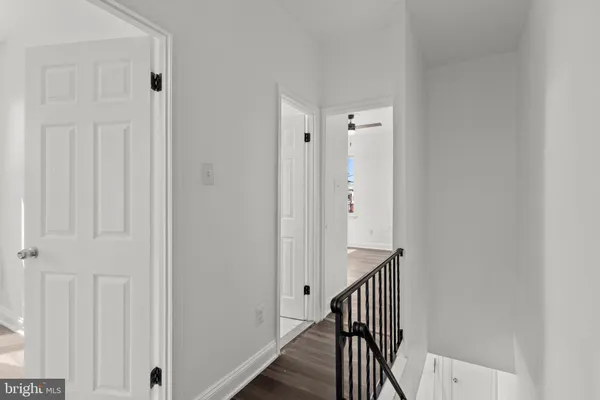 a view of a hallway with wooden floor and entryway