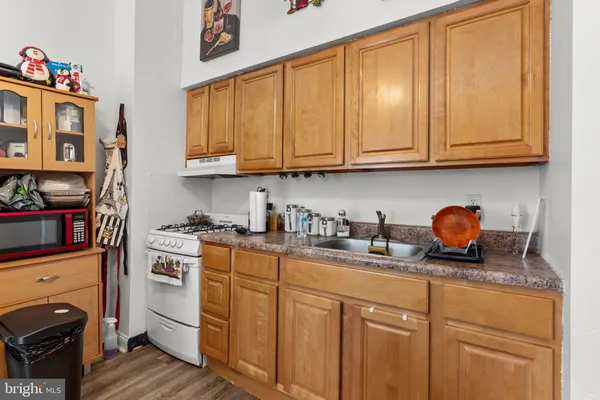 a kitchen with stainless steel appliances granite countertop a sink dishwasher stove and cabinets with wooden floor