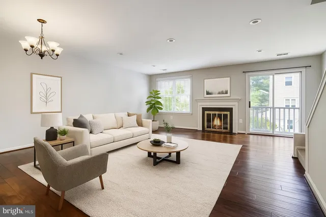 a living room with furniture a fireplace and a chandelier