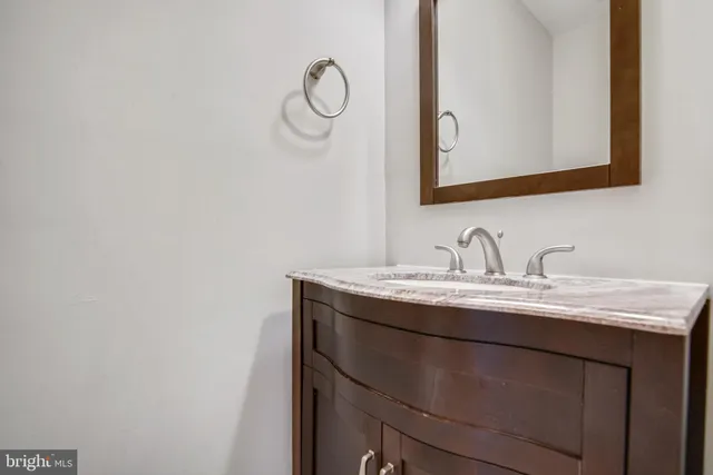 a bathroom with a granite countertop sink a mirror and vanity