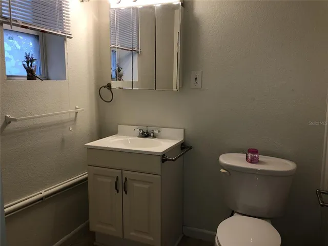 a bathroom with a sink mirror and toilet
