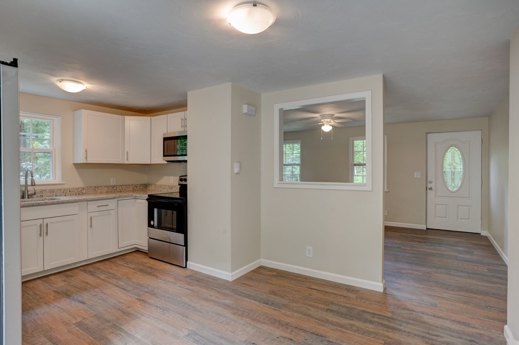 111 Bemis Road Warren, MA 01585 - Photo 6 of 25 a kitchen with wooden floors and white appliances