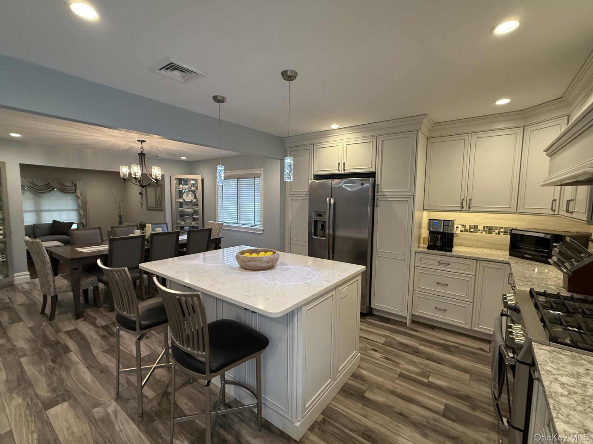 3 Pimlico Court Commack, NY 11725 - Photo 6 of 33 a kitchen with a table chairs refrigerator and microwave