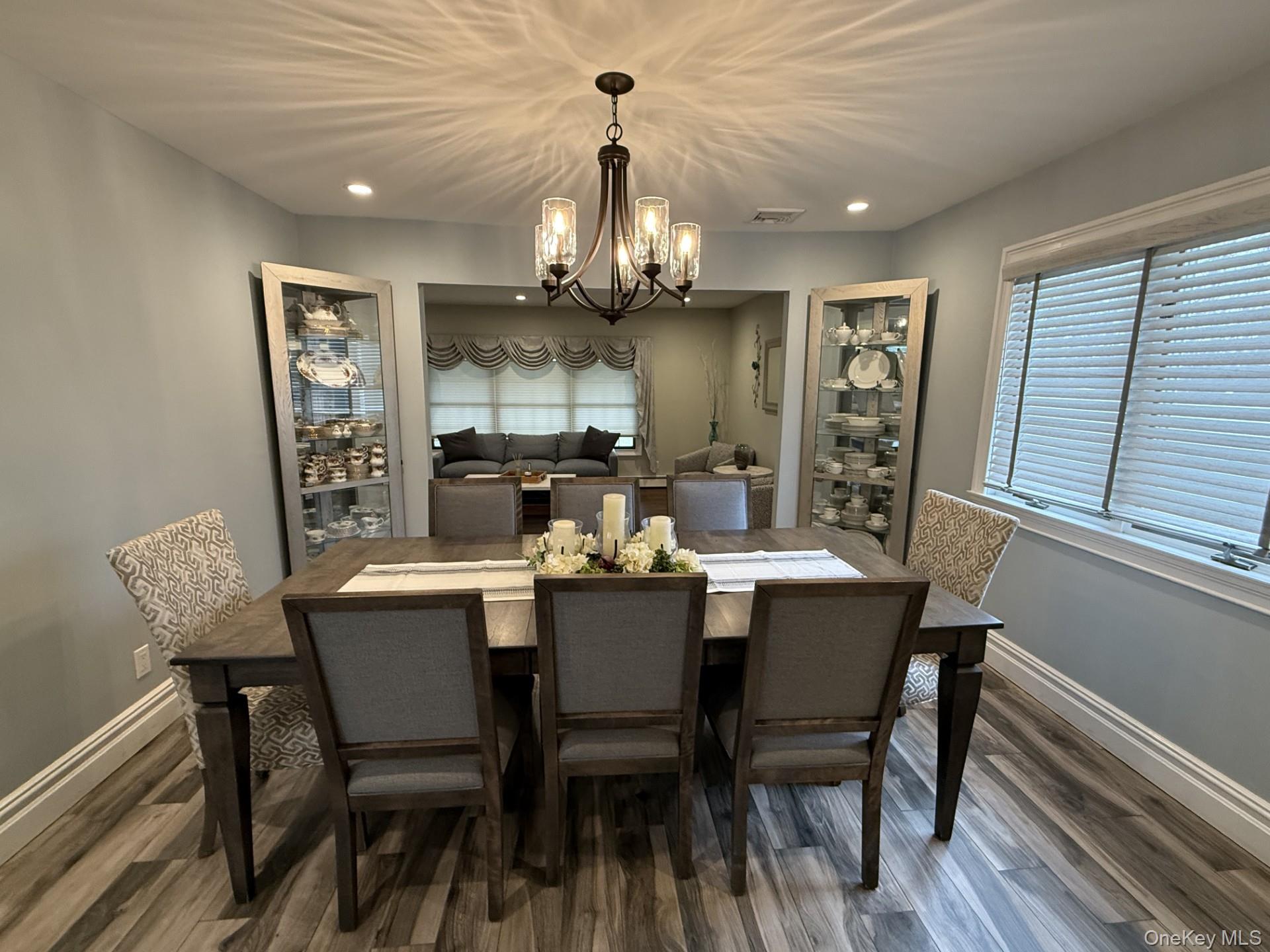 3 Pimlico Court Commack, NY 11725 - Photo 10 of 33 a dining room with wooden floor a chandelier a wooden table and chairs