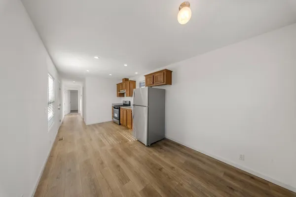 a view of empty room with wooden floor