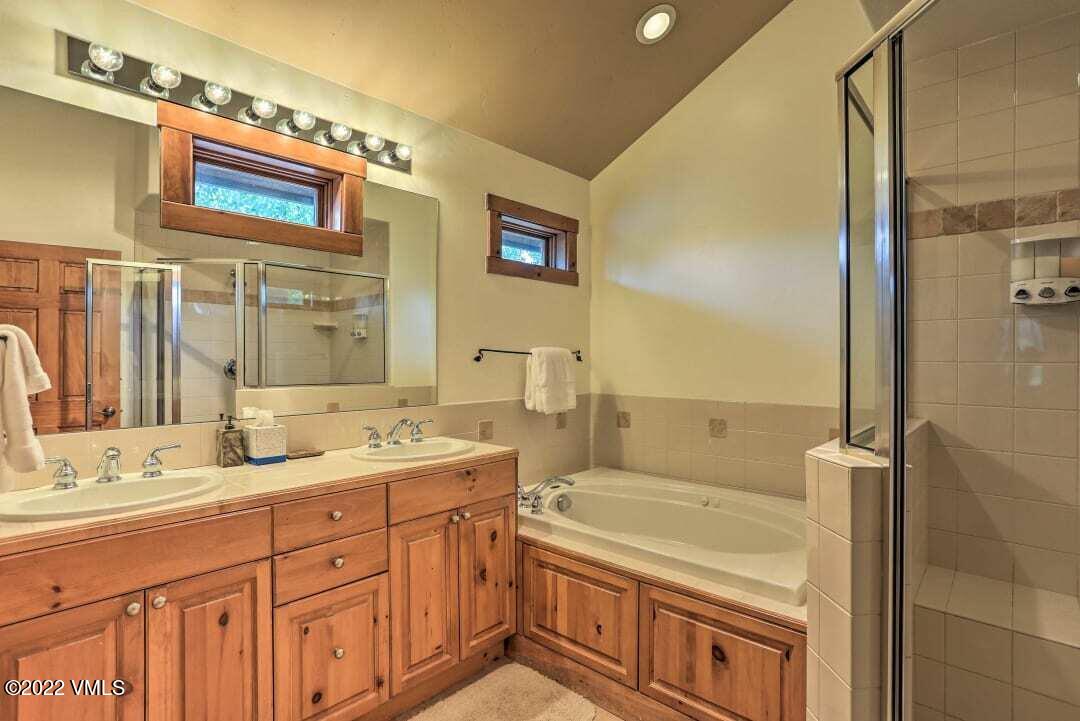 178 Knudson Ranch Road Edwards, CO 81632 - Photo 24 of 26 a bathroom with a granite countertop double vanity sink a mirror and a shower