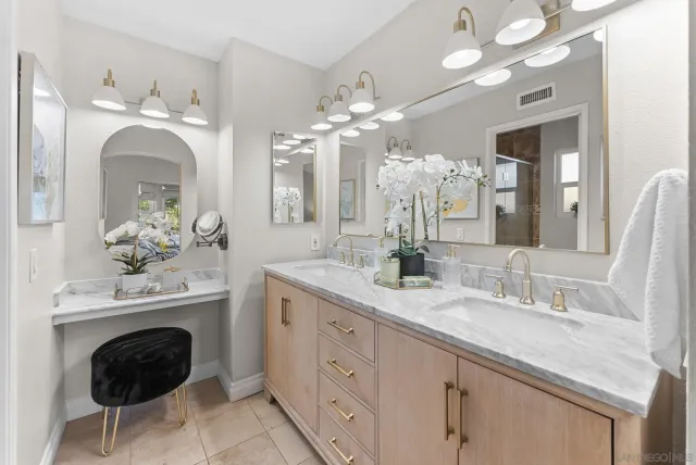 a spacious en suite bathroom with a sink double vanity and a mirror