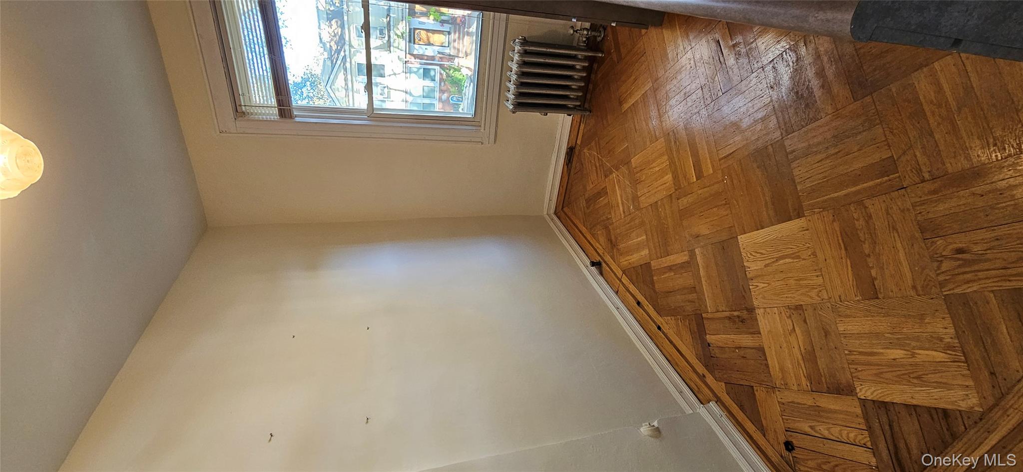 78-54 75th Street Queens, NY 11385 - Photo 23 of 31 Unfurnished room with baseboards and radiator heating unit