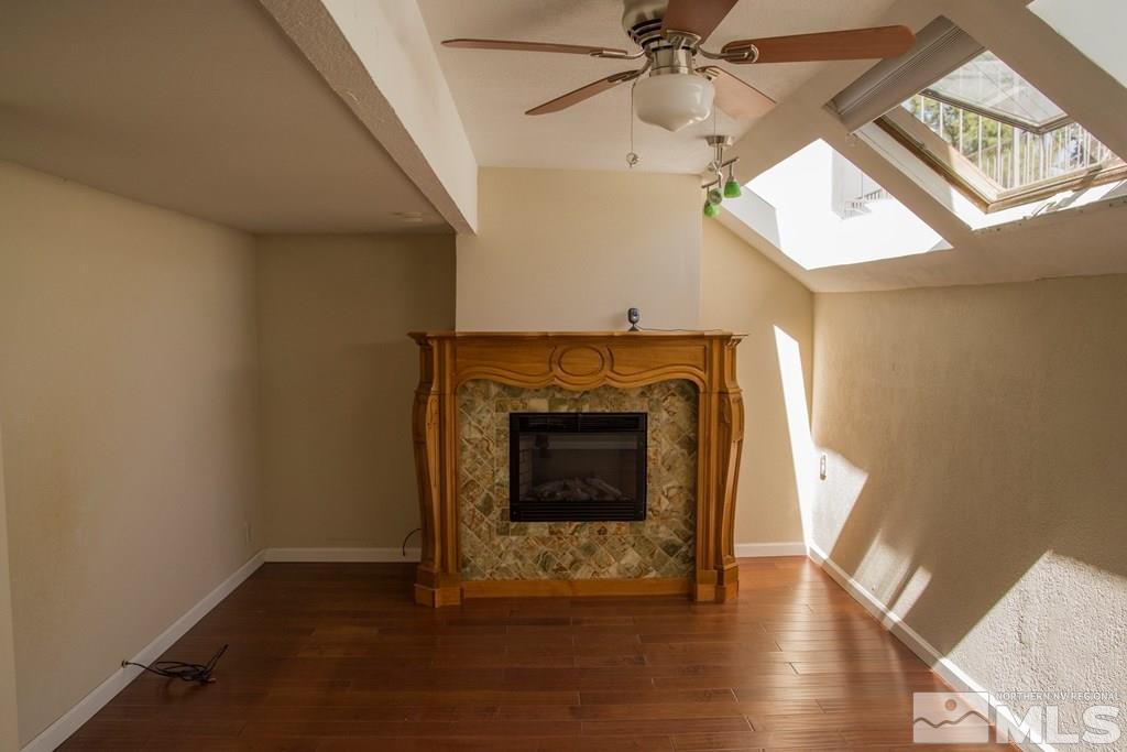 3735 Christopher Circle Reno, NV 89503 - Photo 15 of 19 an empty room with wooden floor a fireplace a ceiling fan and wooden floor