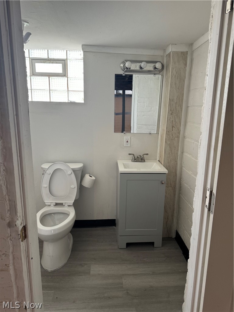 3550 Pennington Road Cleveland, OH 44120 - Photo 14 of 16 Basement Bathroom with wood-type flooring, vanity, and toilet