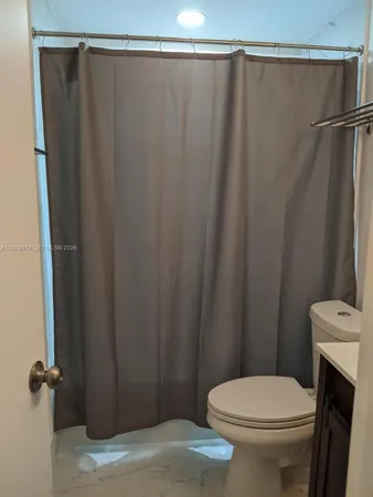 a white toilet sitting next to a shower curtain