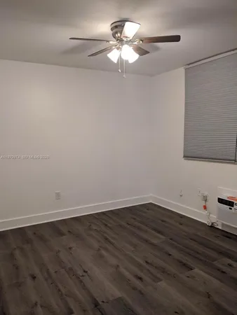 a view of a room with wooden floor and a ceiling fan