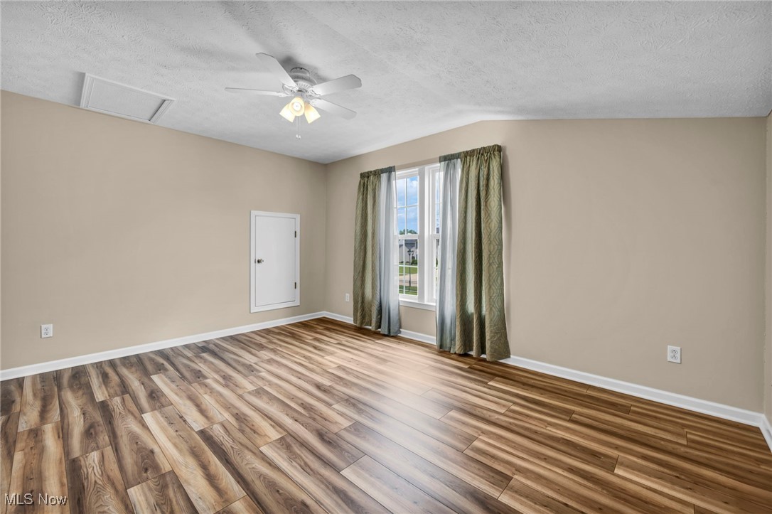143 Stone Ridge Way Berea, OH 44017 - Photo 33 of 47 Spare room featuring wood finished floors, a textured ceiling, attic access, and a ceiling fan